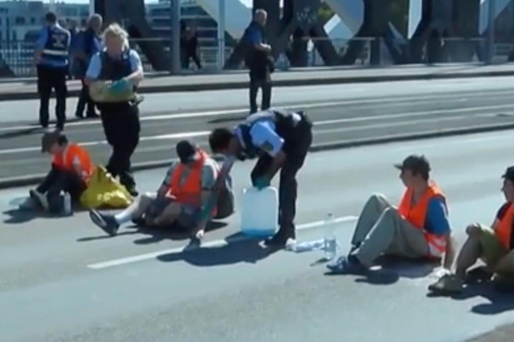 Cop accused of dumping oil on climate protester blocking road