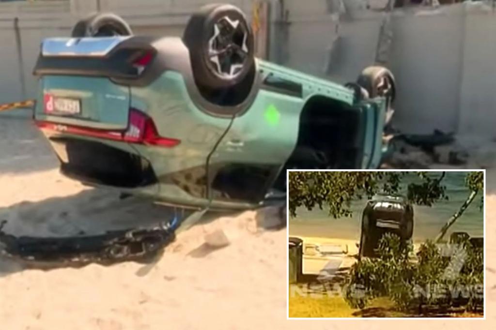 Footage captures insane moment car crashes through concrete wall, flips onto crowded beach